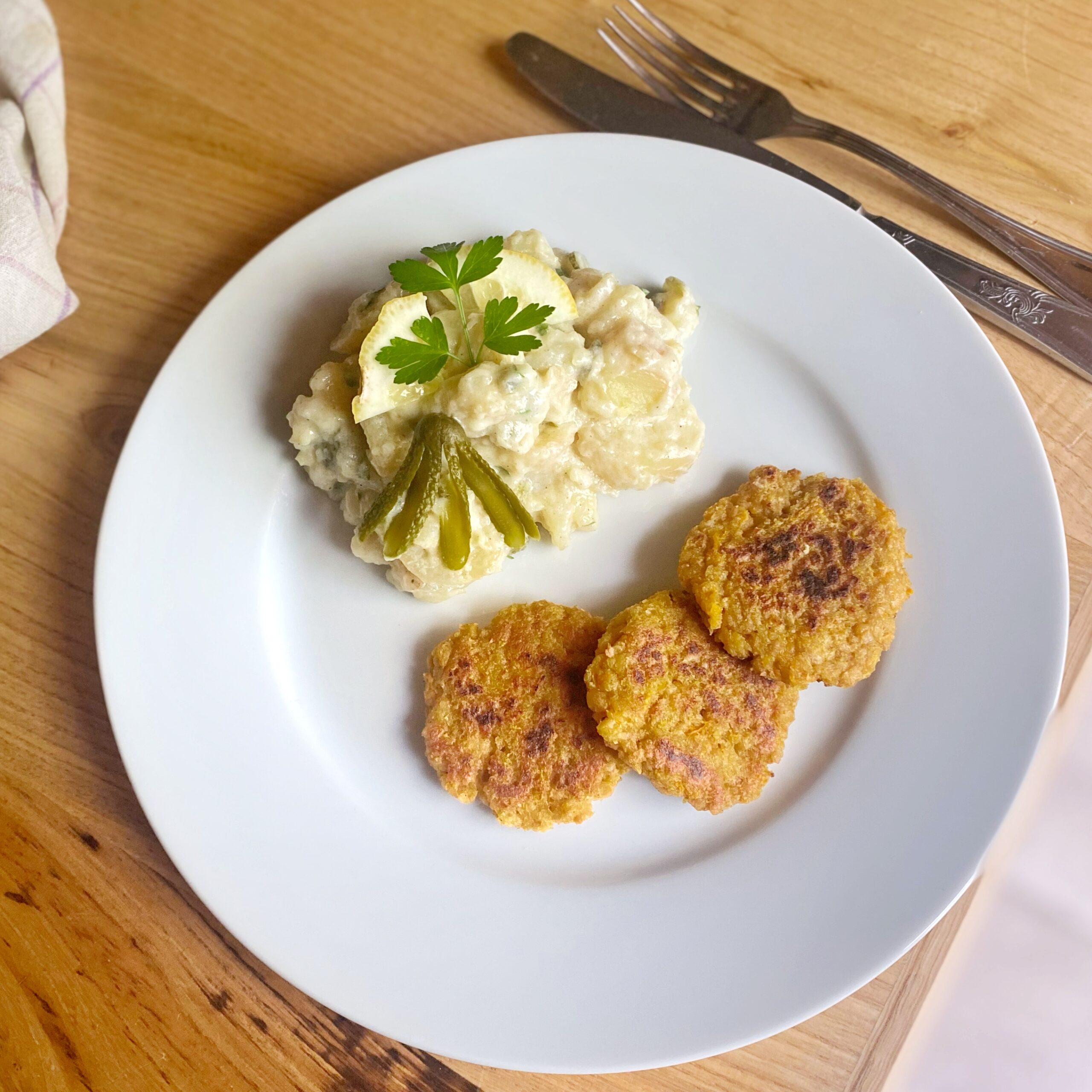 soy patties and potato mayonnaise salad on a white plate