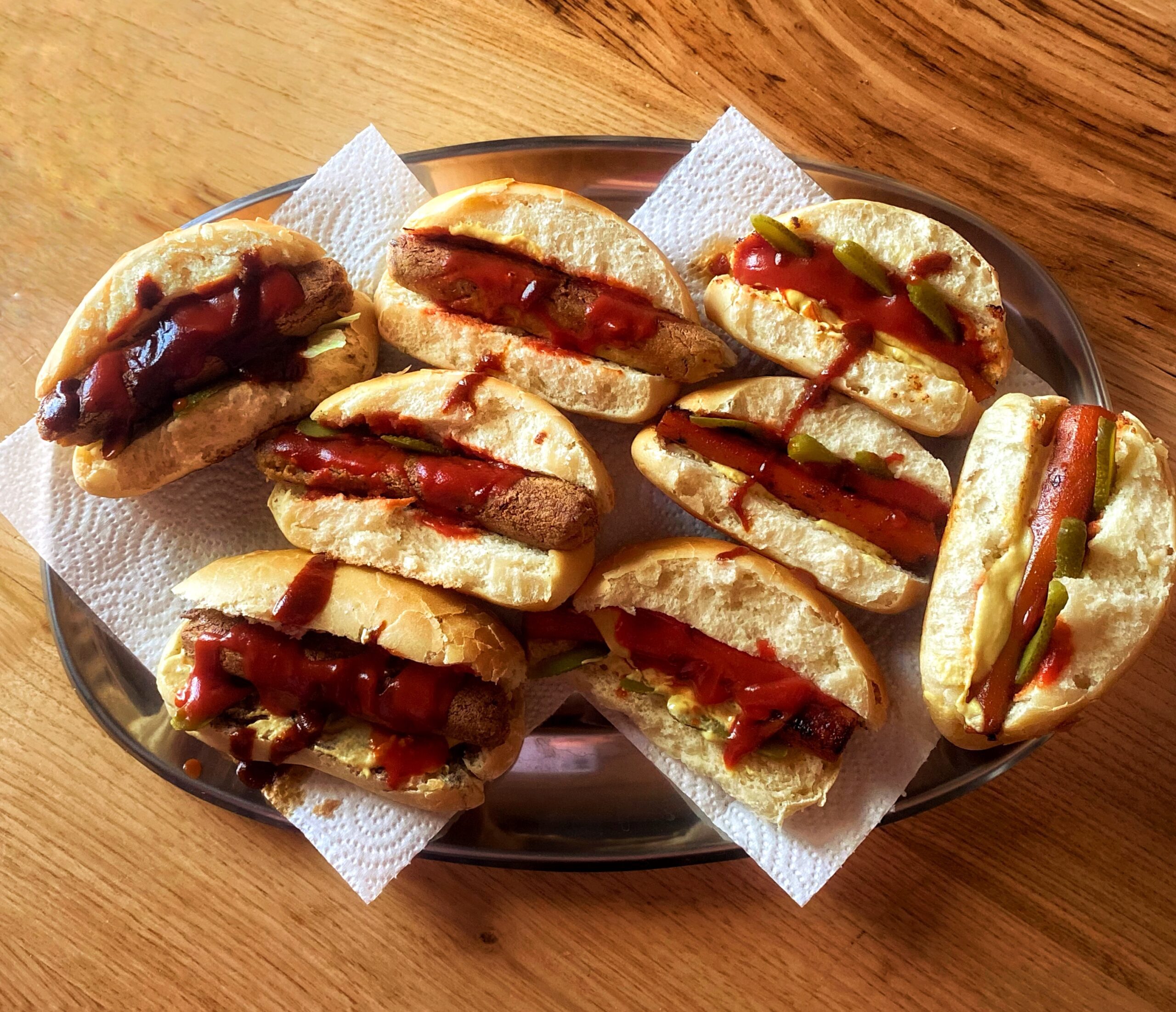 vegan hot dogs on a silver tray placed on a wooden table