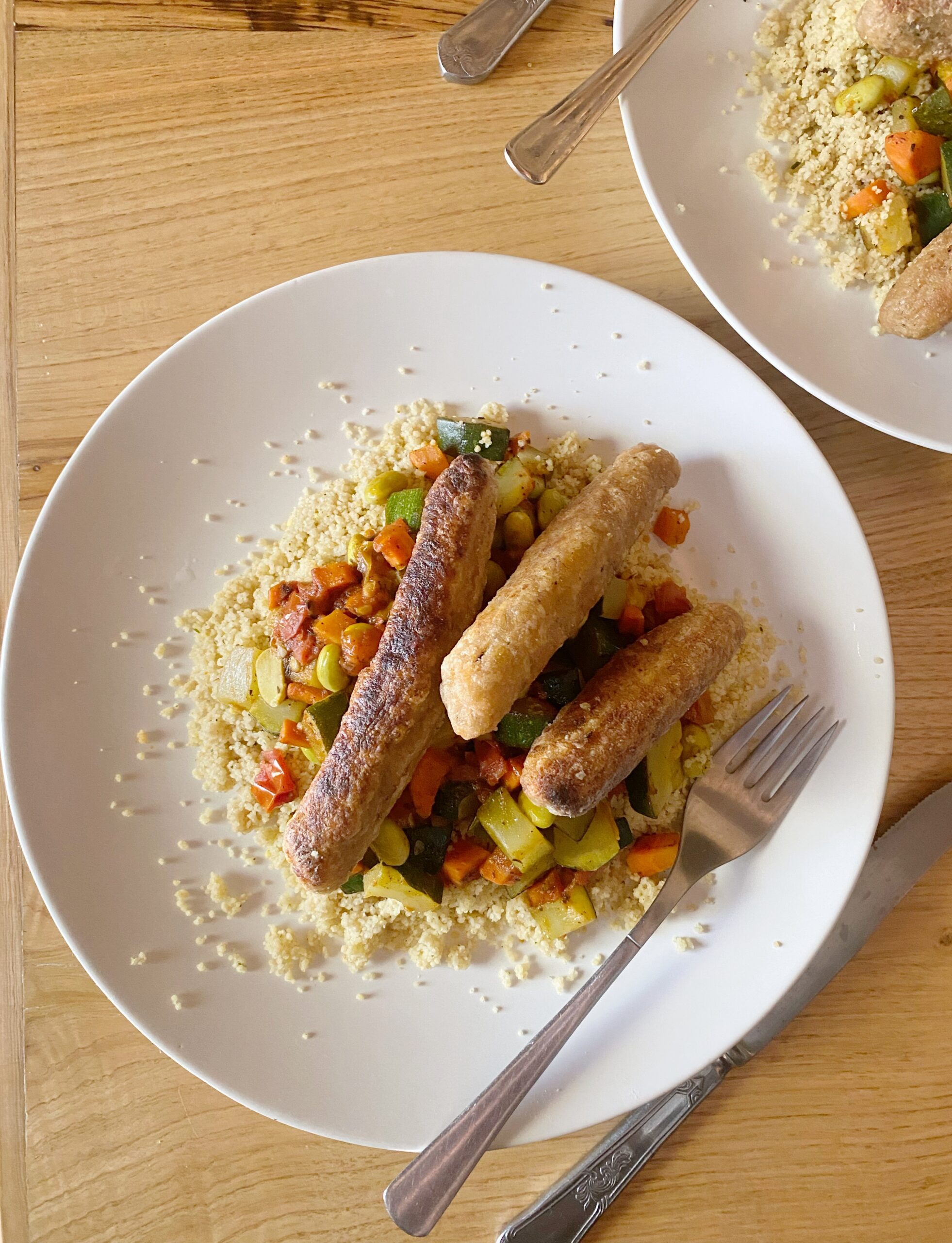 jackfruit sausages on couscous on a white plate