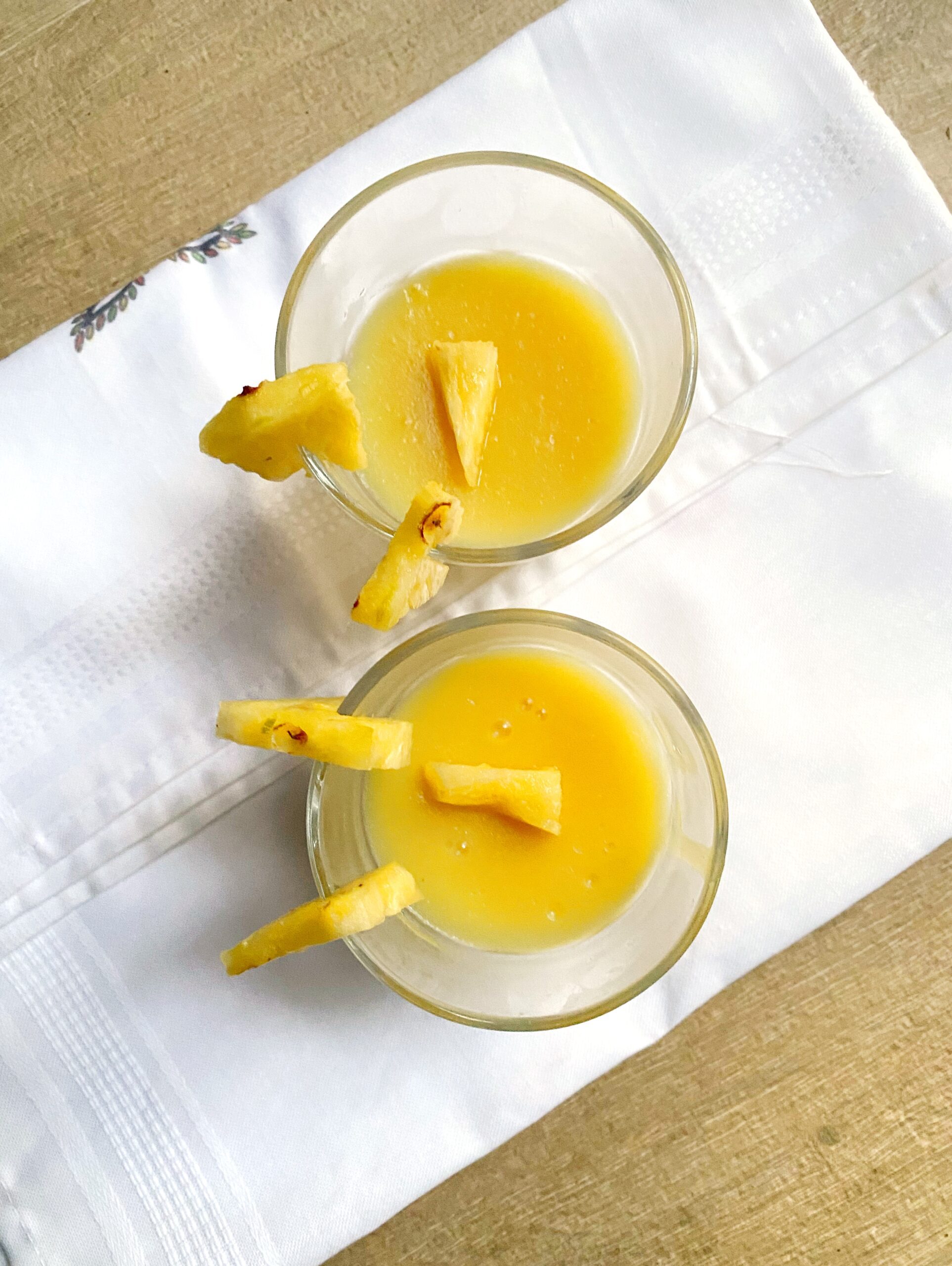 vegan pineapple pudding in two glasses on a white cloth