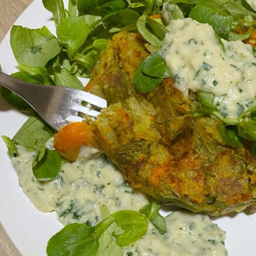 vegetable roast with lettuce and parsley sauce on white plate